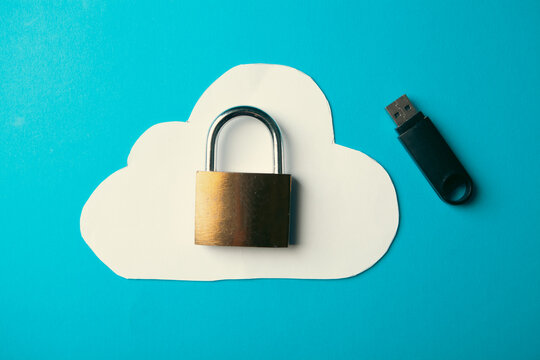 Cloud computing security concept with USB flash drive and padlock on blue background