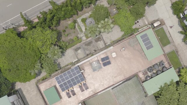 Bird&rsquo;s-Eye View of an Urban Neighborhood with Tree-Lined Road, Residential Rooftops and Solar Energy Systems