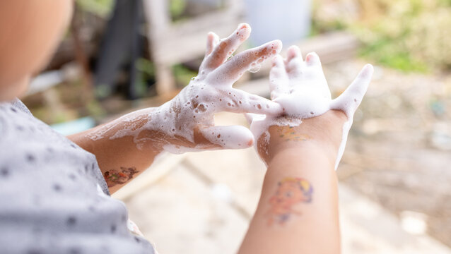 Close Up Child Washing Hands with Soap Foam Outdoor,Close up macro photo of a little child washing hands thoroughly with white soap foam outdoor for good hygiene and virus protection concept.