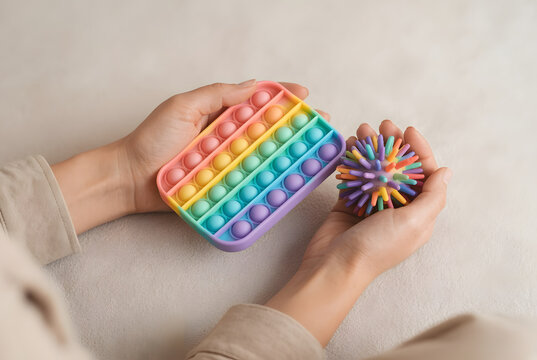 Close-up of hands using colorful sensory fidget toys for adult stress relief