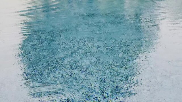 Swimming pool water surface and ripple wave with blue mosaic tiles