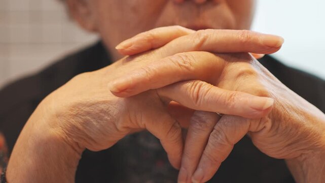 Close Up of Older Person with Hands Clasped Near Face