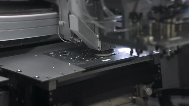 Pick and place machine heads over circuit board. SMT line in electronics factory. Smartphone production