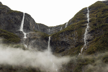 Broad cascades over a curving cliff in Norway during autumn travel © Olya