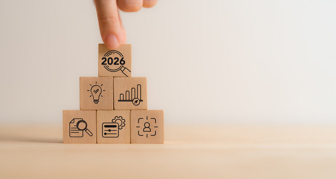 2026 Year in Review. Annual Business Performance Analysis, Strategic Evaluation and Growth Insights. Placing 2026 review block atop a wooden with business icons. Annual performance analysis.