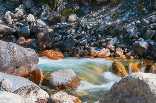 Mountain Stream Flowing Past Rocky Shoreline