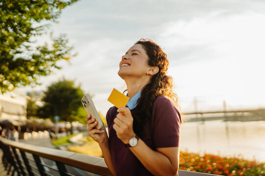 Woman celebrating online shopping success with credit card