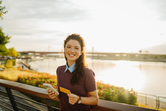 Woman holding credit card and smartphone shopping online