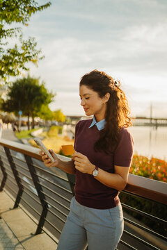 Woman shopping online using credit card and smartphone outdoors