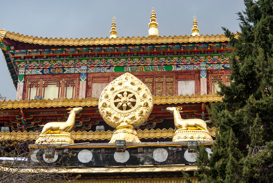 Gilded Dharma Wheel (Dharmachakra) on the front  facade of a Buddhist temple in Shnagri-La, Yunnan, China, Asia