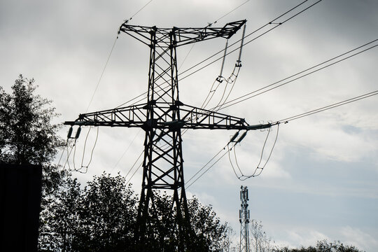 Overhead transmission wires connect through insulators and looping jumpers on a steel lattice tower, illustrating conductor support and electrical isolation for utilities