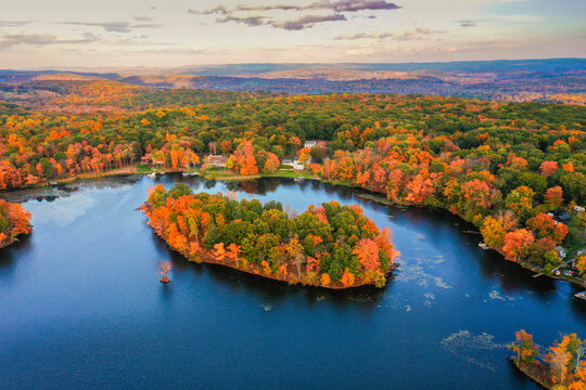 Kemah Lake in Hampton Township, Sussex County, NJ, surrounded by brilliant fall foliage at dusk aerial drone