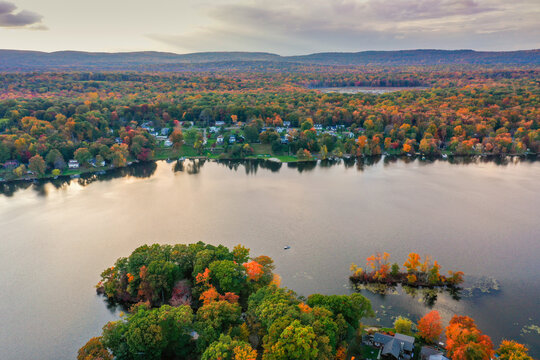 Kemah Lake in Hampton Township, Sussex County, NJ, surrounded by brilliant fall foliage at dusk aerial drone