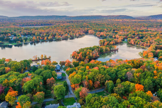 Kemah Lake in Hampton Township, Sussex County, NJ, surrounded by brilliant fall foliage at dusk aerial drone