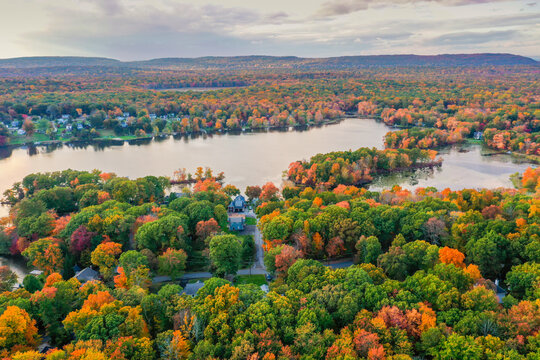 Kemah Lake in Hampton Township, Sussex County, NJ, surrounded by brilliant fall foliage at dusk aerial drone