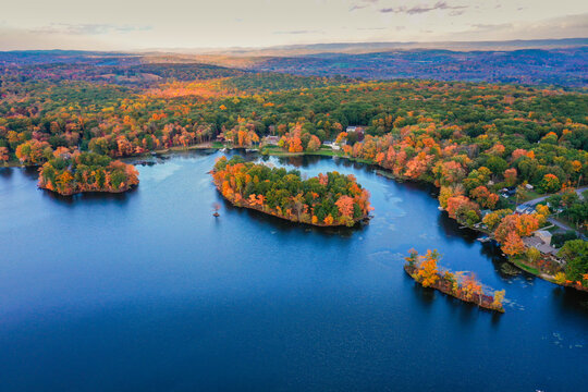 Kemah Lake in Hampton Township, Sussex County, NJ, surrounded by brilliant fall foliage at dusk aerial drone