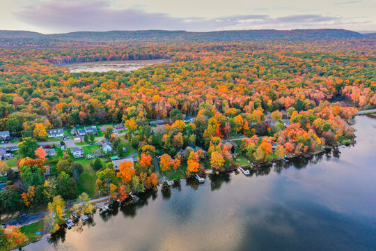 Kemah Lake in Hampton Township, Sussex County, NJ, surrounded by brilliant fall foliage at dusk aerial drone