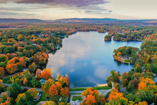Kemah Lake in Hampton Township, Sussex County, NJ, surrounded by brilliant fall foliage at dusk aerial drone