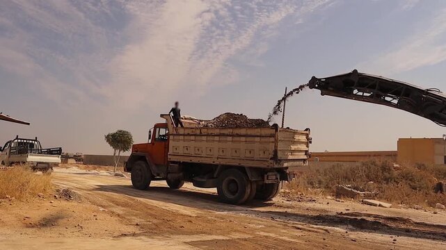 Road workers remove asphalt in Aleppo, Syria, in 2026, documenting postwar reconstruction, infrastructure renewal, urban development, and heavy machinery in action.