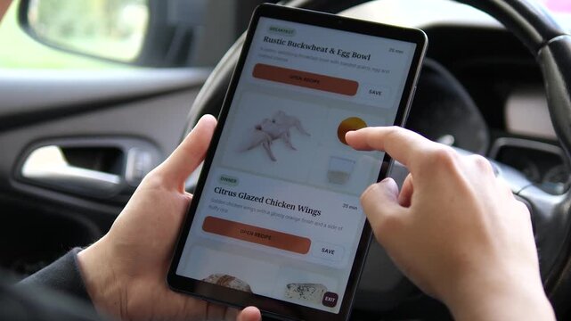 Person scrolls through a digital recipe collection on a tablet, exploring breakfast, chicken and artisan cheese dishes in a modern mobile cooking and meal-planning experience.