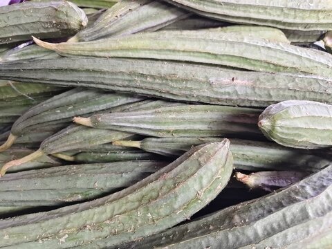 Chinese okra (oyong or ridge gourd) is a long, green vegetable with distinct ridges. It has a mild, sweet taste and spongy flesh that turns tender and juicy when cooked in soups.
