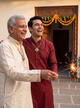 Diwali celebration with happy father and son holding sparkler at home