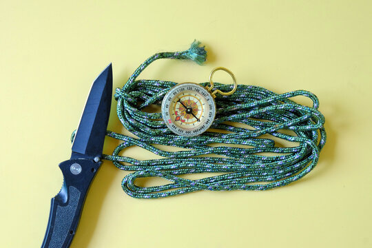 Vintage compass with knift on rope,camping concept.