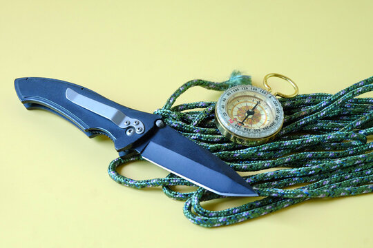 Vintage compass with knift on rope,camping concept.