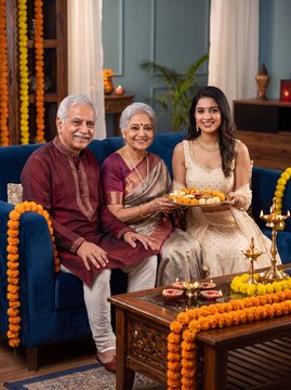 Diwali family celebration with sweets and oil lamps on blue sofa in