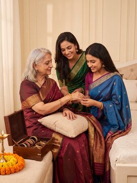 Indian women applying henna during Raksha Bandhan celebration with