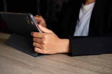 Close-up photograph of a business professional holding a tablet horizontally at a desk, representing mobile computing, digital business tools and professional technology use. © Ojah