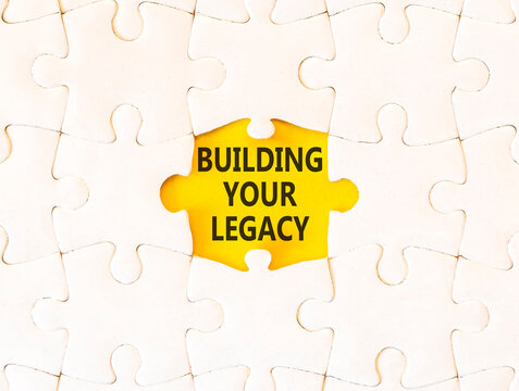 Building your legacy words symbol. Concept words Building your legacy on beautiful white puzzle. Beautiful yellow background. Business building your legacy concept. Copy space.