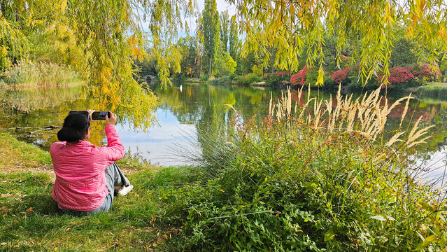 Frau fotografiert im herbstlichen Park