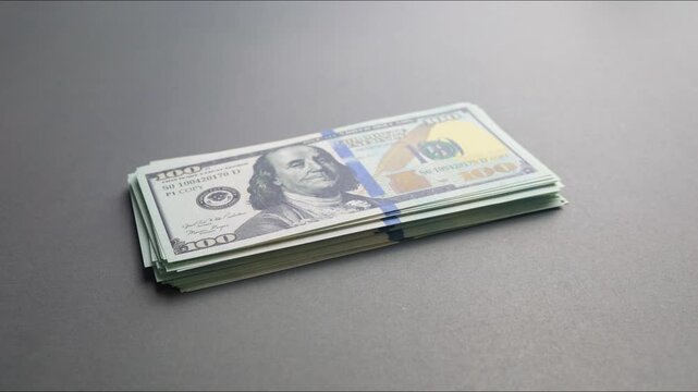 A growing stack of one hundred us dollar bills