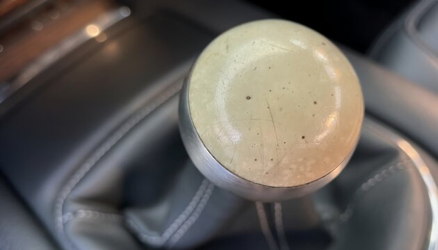 manual transmission gear shift knob closeup vintage car interior leather upholstery automotive restoration project reference