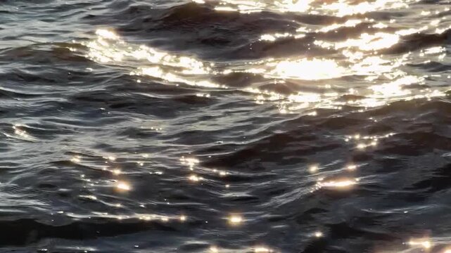 Close-Up of Sea Water Waves with Golden Sunlight Reflections Surface