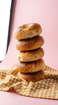 Golden bagels stacked vertically on checkered cloth with copy space
