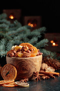 Christmas still-life with dried fruits, nuts, and burning candles.