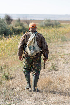 A hunter with a gun in camouflage clothing. A gentleman with a gun, medium shot, unrecognizable.