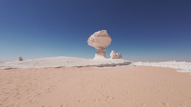 Mushroom-shaped chalk rock formation rising from sandy landscape of White Desert. Wind erosion sculpted pale limestone into unusual natural shape. Sahara el Beyda, White Desert Protected Area, Egypt