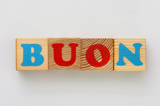 The image features wooden alphabet blocks arranged to form the Italian word BUON , which translates to good in English