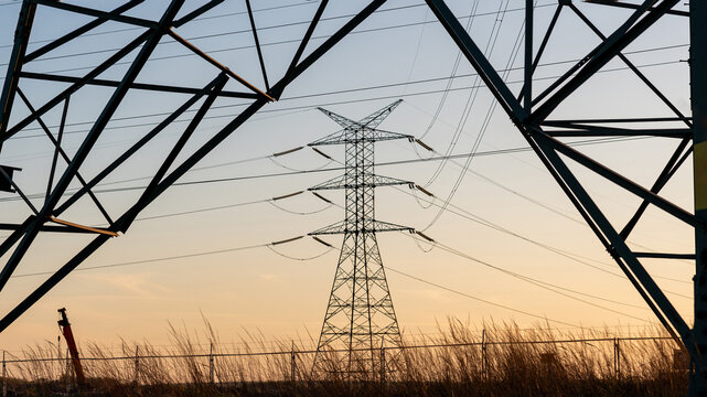 Energy grid infrastructure with high voltage pylons.