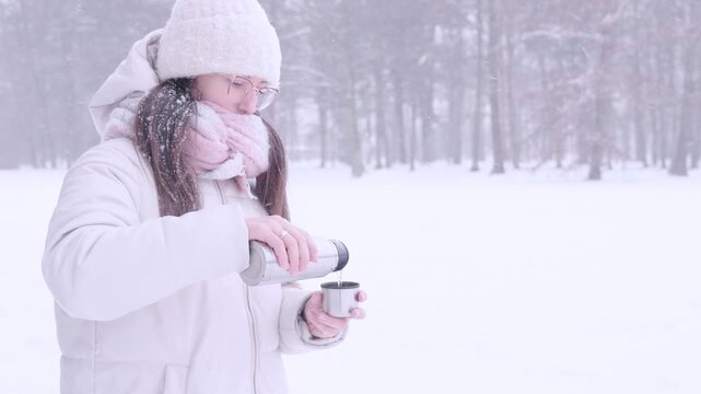 Woman snowy day. Girl enjoying hot beverage outdoors. Slow living concept.