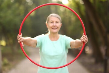 Senior woman with hula hoop in park, selective focus © New Africa