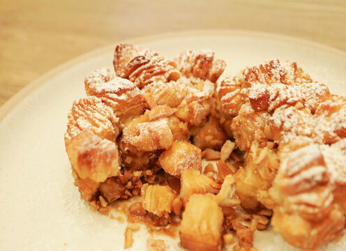 Close-up of a broken monkey bread showing soft buttery texture and chopped almonds inside