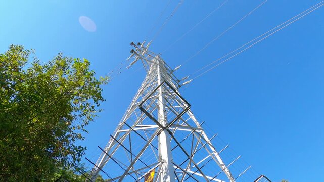 Looking Up at a Transmission Tower Against a Blue Sky