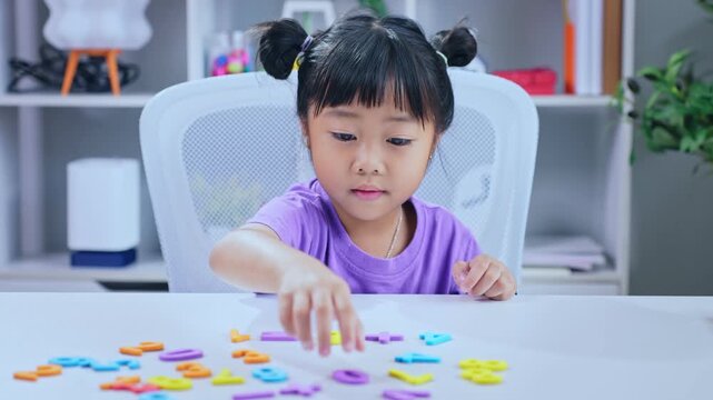 Asian girl counting numbers with fingers and celebrating success after solving math puzzle at desk