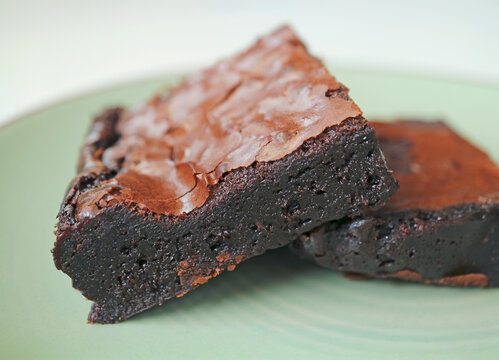 Close-up of a homemade dark chocolate fudgy brownie slice served on a plate