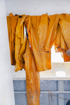 Yellow fishing waterproofs hanging inside a working boat