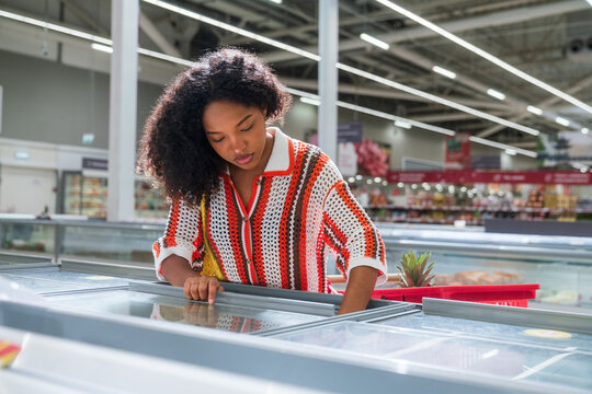 Woman Shopping in Supermarket Freezer Section